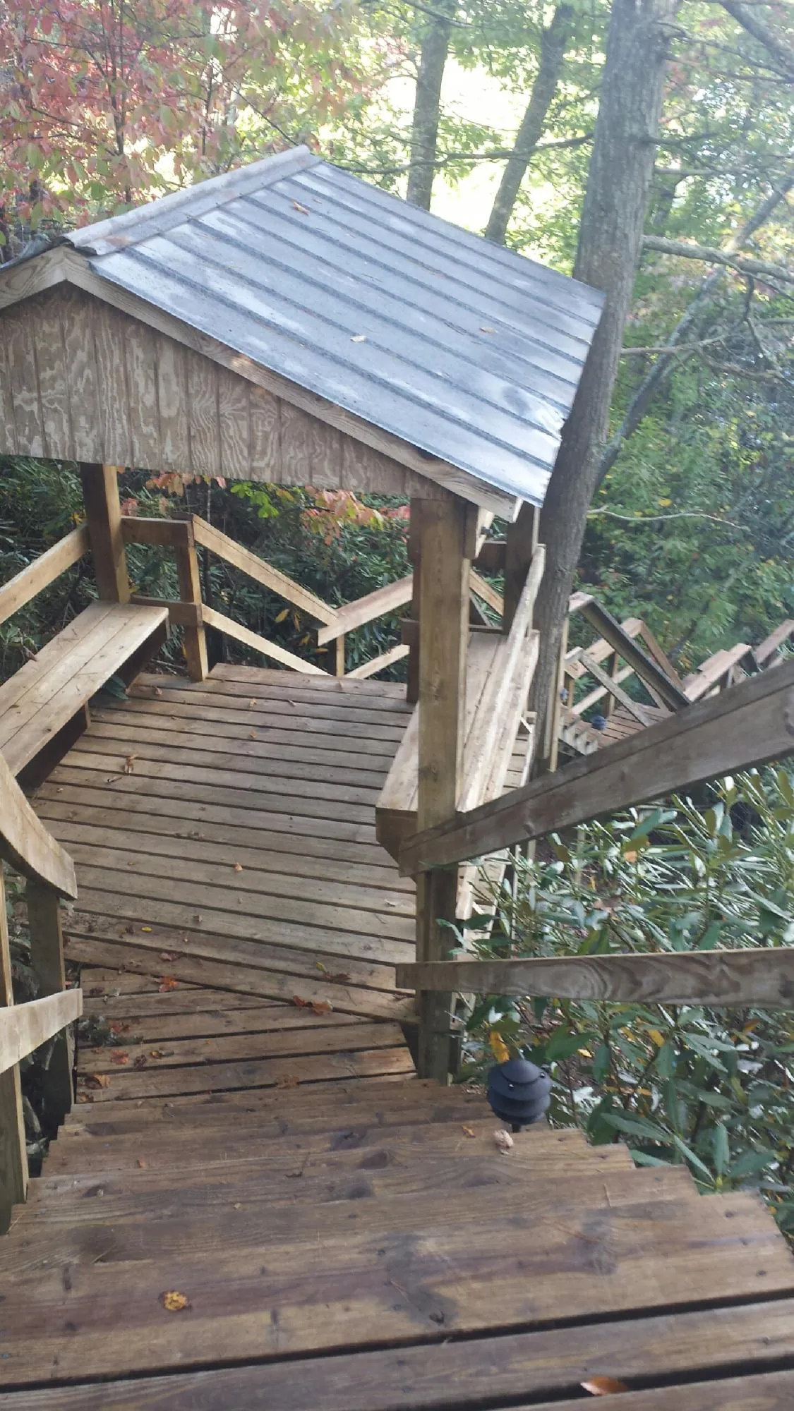 Metal roofed shelter over wooden steps on a wooded walkway — Skylight Repair & Installation work by our crew in Alexander